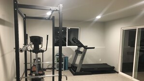 A home gym with a pull-up bar, weight bench, and a treadmill. - Perfect get away that is minutes from Legendary Downtown Sturgis! (Sturgis)