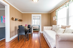 Relax in this stylish living area with a dining table, sofa, and window offering a view.