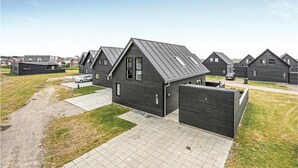 A modern residential area with dark-colored houses featuring pitched roofs and large windows.