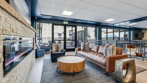 A modern lounge area with a stone wall, leather sofa, round wooden coffee table, and metal chairs. - Luxury|In Town|Peak 9|Ski-In/Out (Breckenridge)