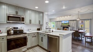 A modern kitchen with stainless steel appliances, a dishwasher, and a large island. - Luxury|In Town|Peak 9|Ski-In/Out (Breckenridge)
