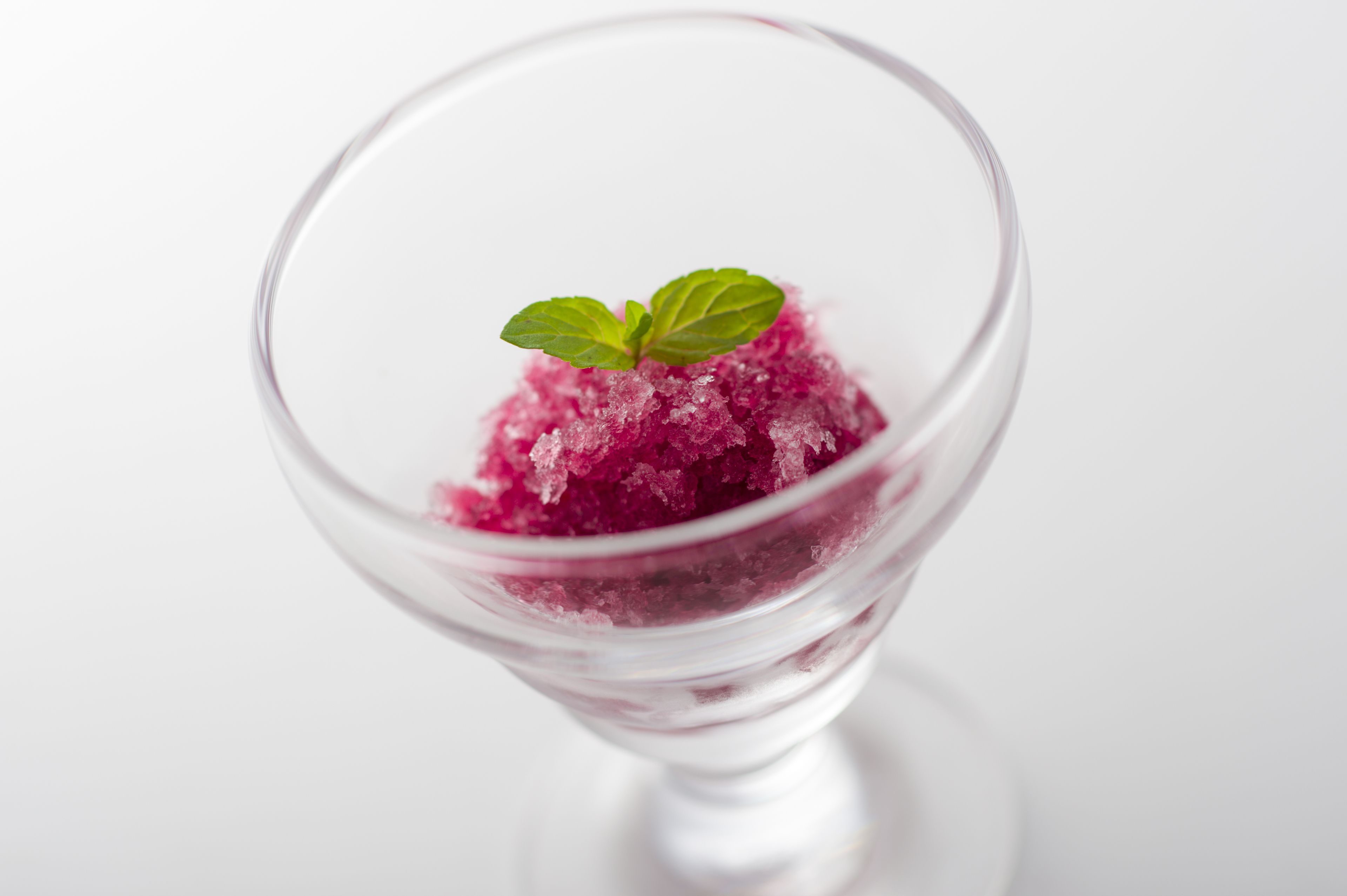 Postre de vidrio transparente con adorno de menta.