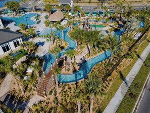 A resort with multiple swimming pools, palm trees, and a winding water slide. - G-Gated Resort-5 miles to Disney-2 FREE Water Park (Osceola County)