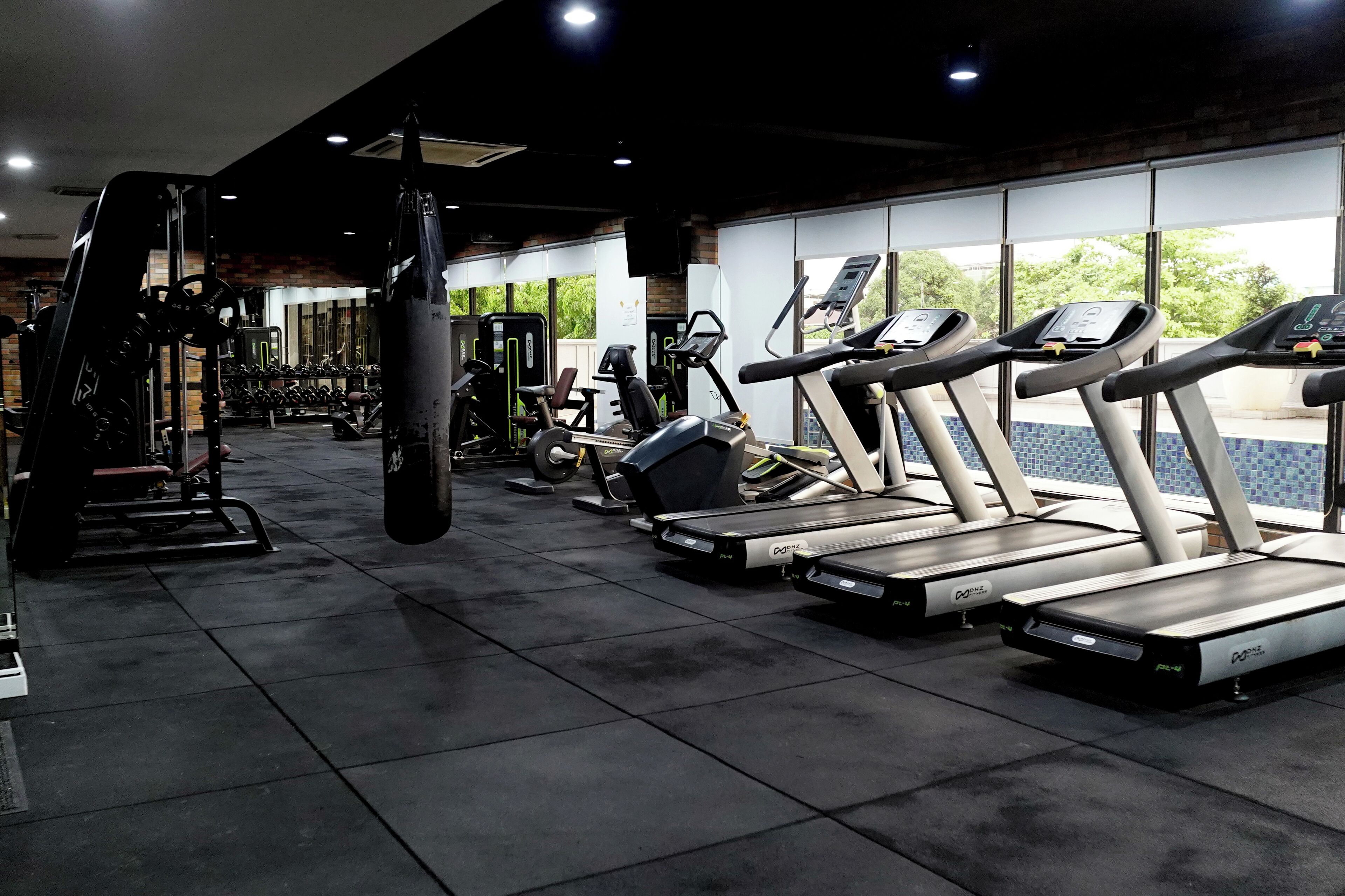 A gym with treadmills, weight machines, and a punching bag.