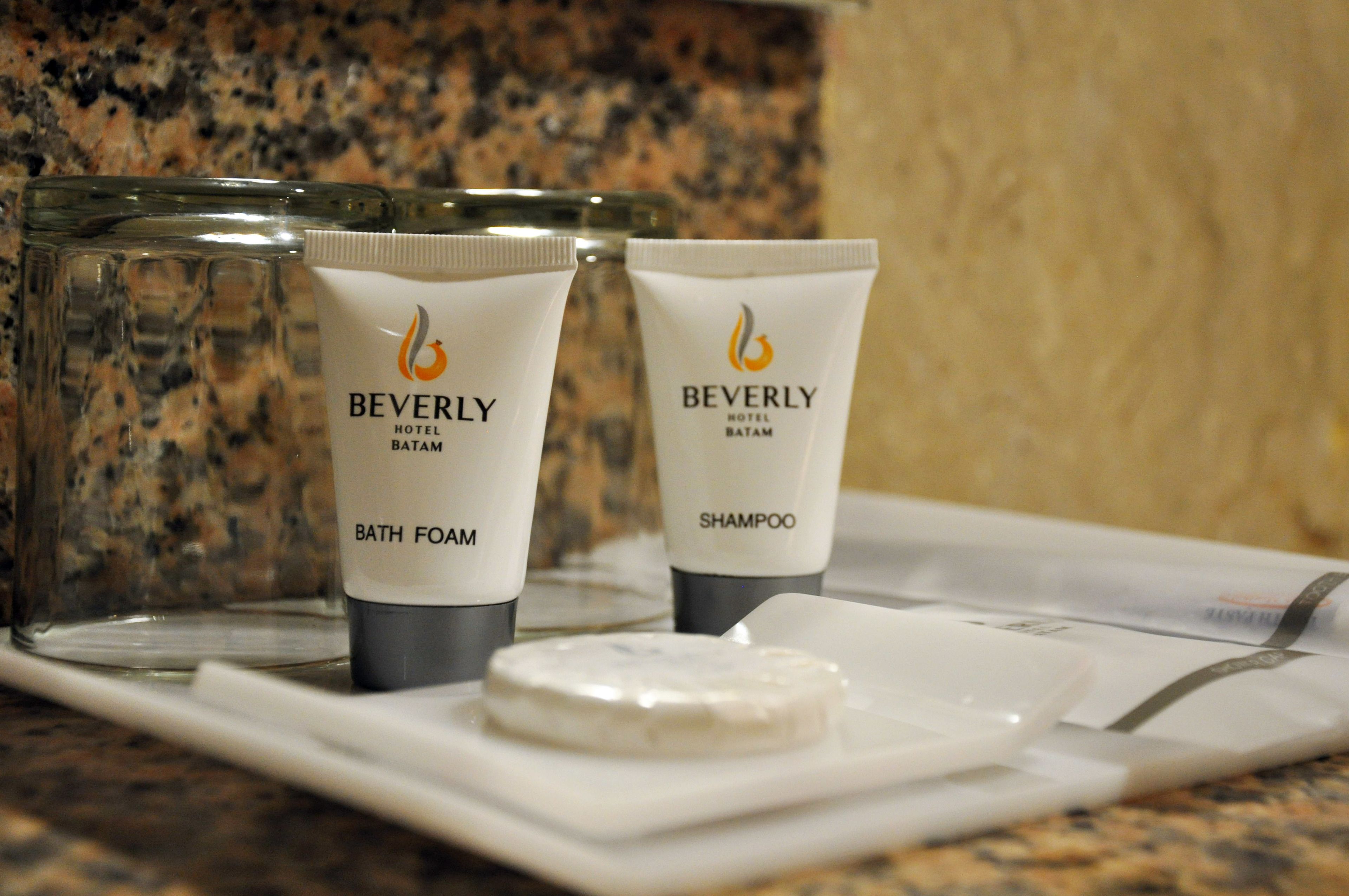 Two bottles of Beverly Hotel Batam bath foam and shampoo on a tray.