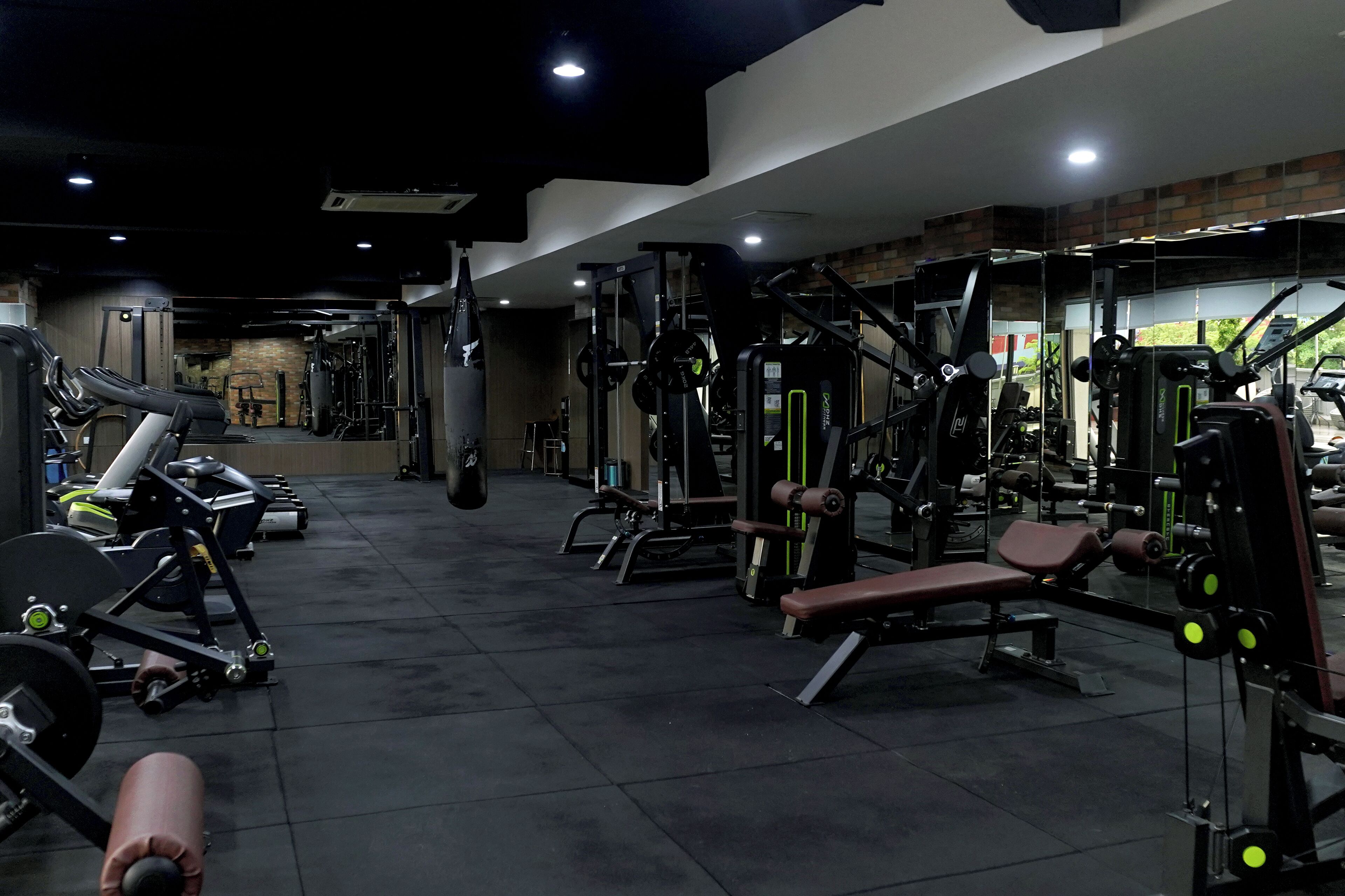 A gym with various exercise machines, benches, and weights.