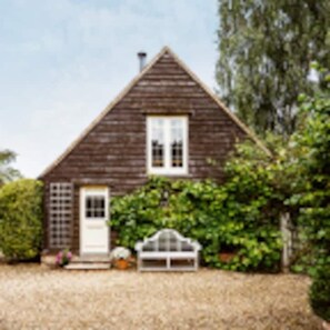 Traditional house with a central entrance, porch, and a glass-enclosed structure.
