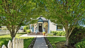 A house with a front porch, a mailbox, and a small garden. - Victorian Secrets 1897 Home - Curious? Eclectic, convenient & ❤️ of wine country (Newberg)