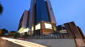 Um edifício moderno com fachada em vidro destacada e entrada visível.