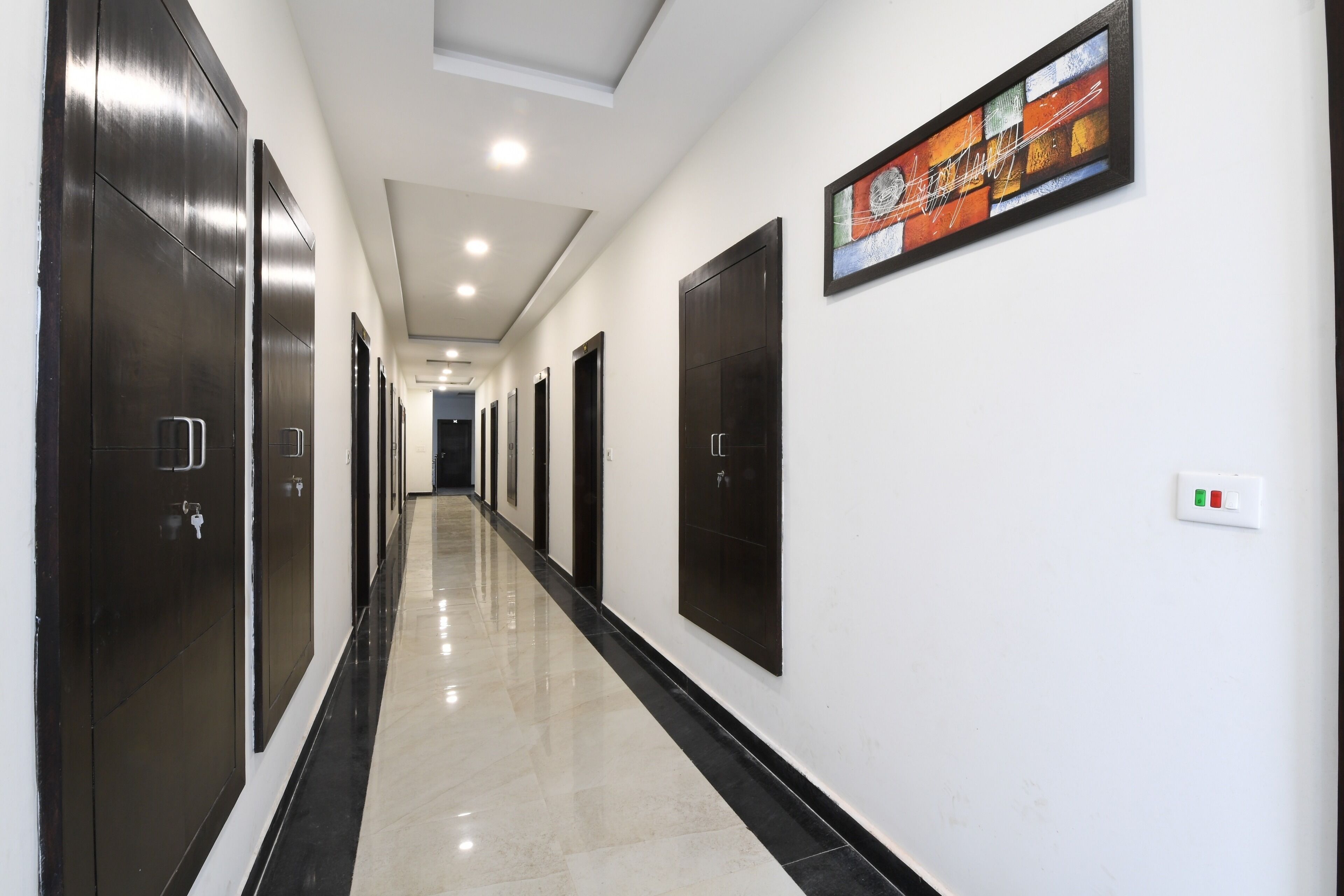 A long, narrow hallway with dark wooden doors on both sides and a polished floor.