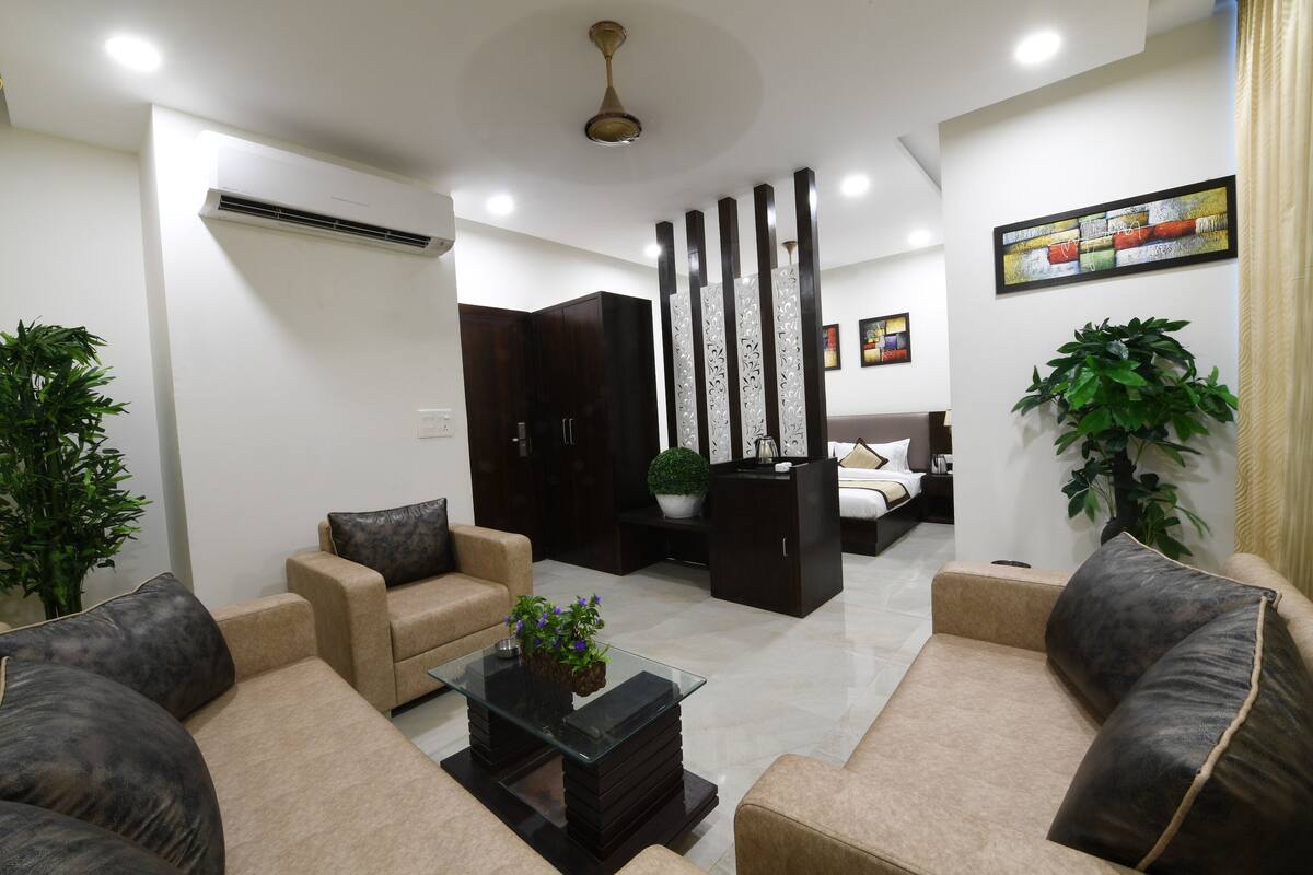 A modern living room with beige sofas, a glass coffee table, and decorative plants.