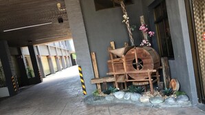 Une allée couverte agrémentée d’une barrique en bois rustique et de plantes décoratives.