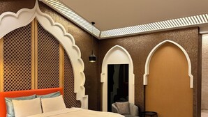 Une chambre à coucher moderne avec un grand lit, un banc et des arches décoratives.