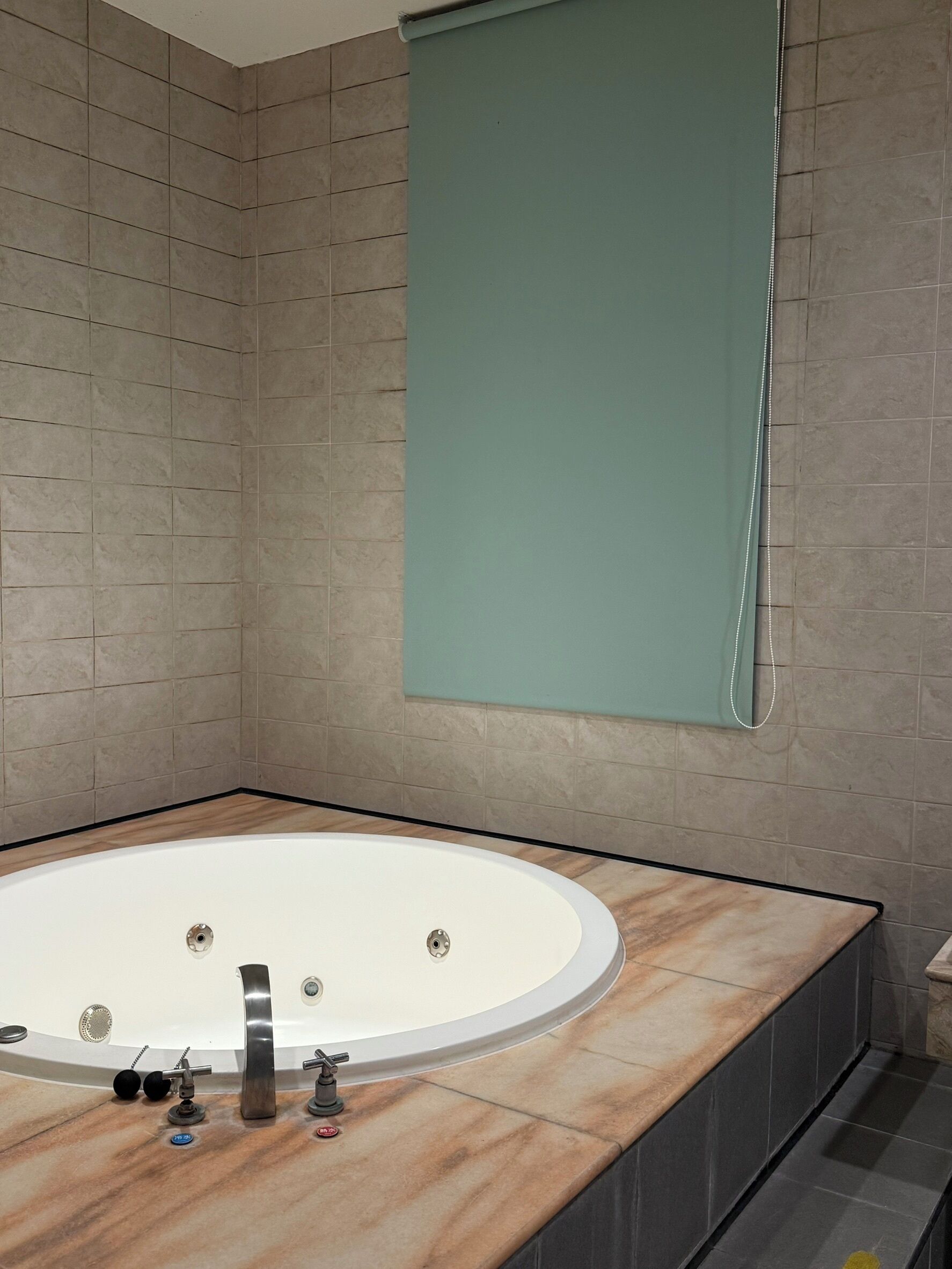 A modern bathroom with a freestanding bathtub, a large mirror, and a marble countertop.