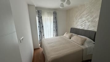 Ein Schlafzimmer mit Bett, Vorhängen und einer Deckenleuchte.