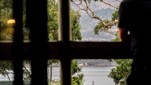 Une vue à travers une fenêtre donnant sur un lac et des montagnes.
