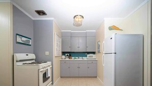 Une cuisine compacte équipée d’une cuisinière à gaz, d’un four, d’un four à micro-ondes et d’un réfrigérateur.