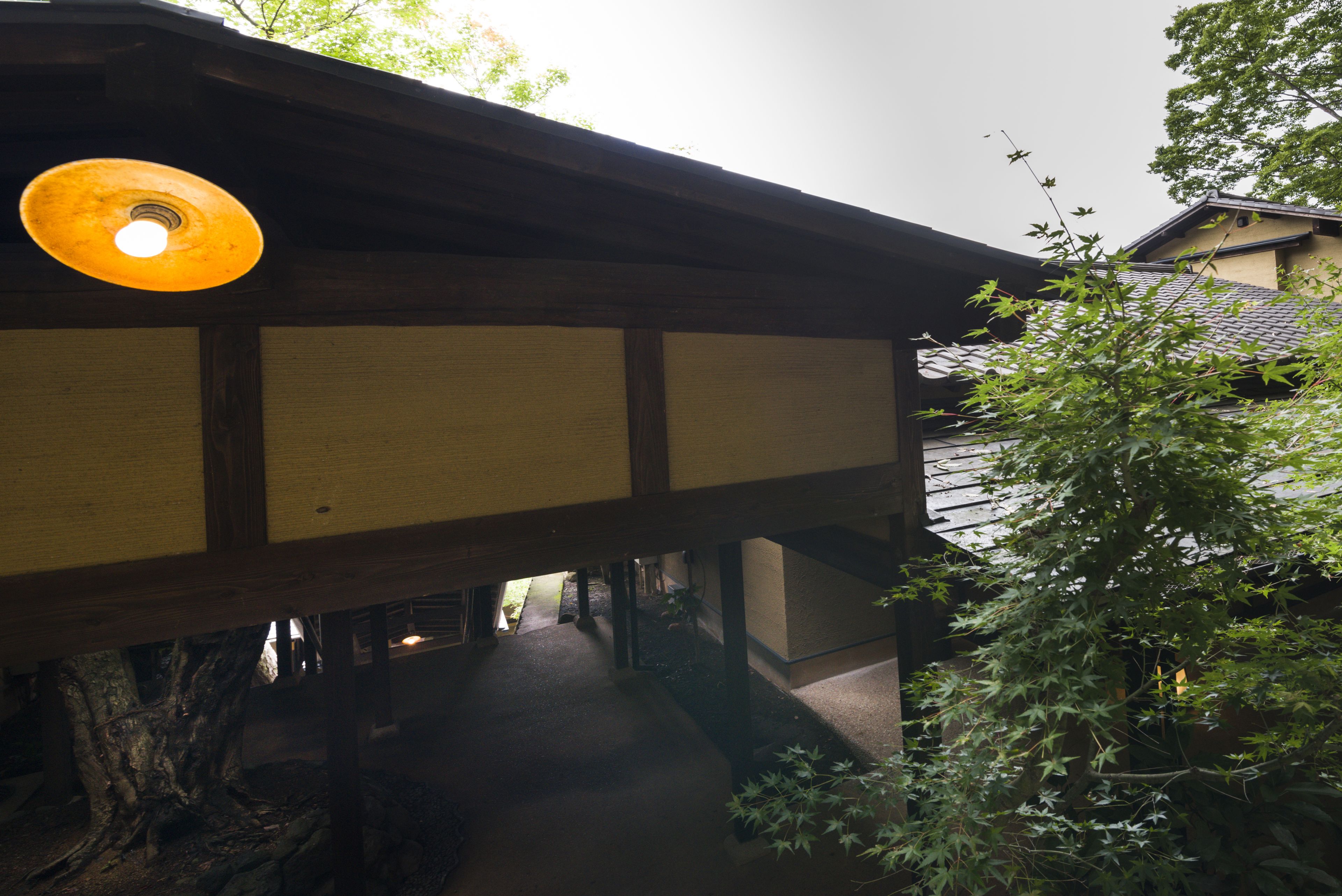 A traditional Japanese building with a wooden structure and a covered walkway.