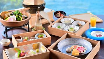 A traditional Japanese meal setup with various dishes and utensils on wooden trays.