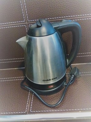 A Grelide electric kettle on a brown leather surface with white stitching. - Sun Guest House (Kowloon)