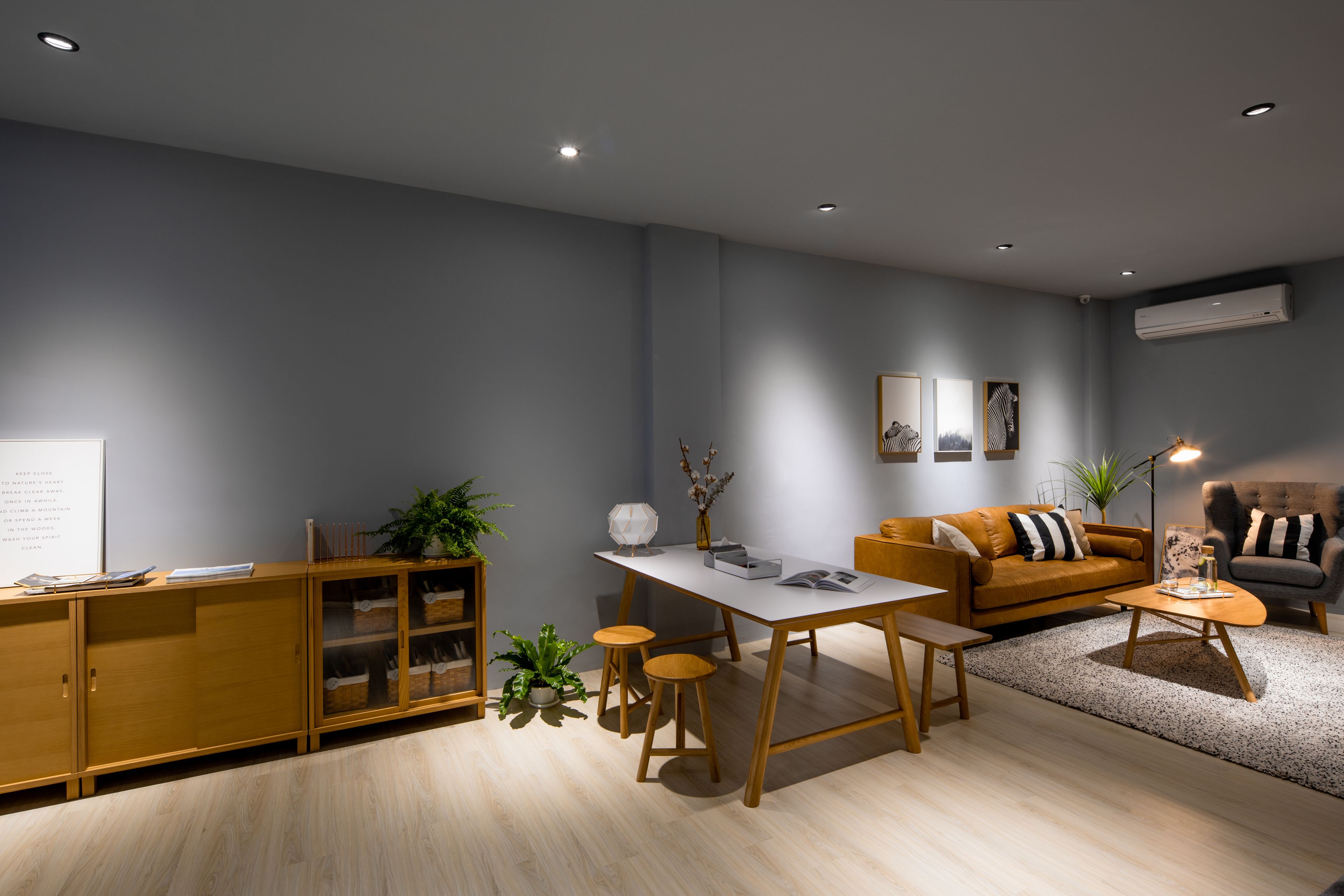 A modern living room with a sofa, coffee table, and a dining area.
