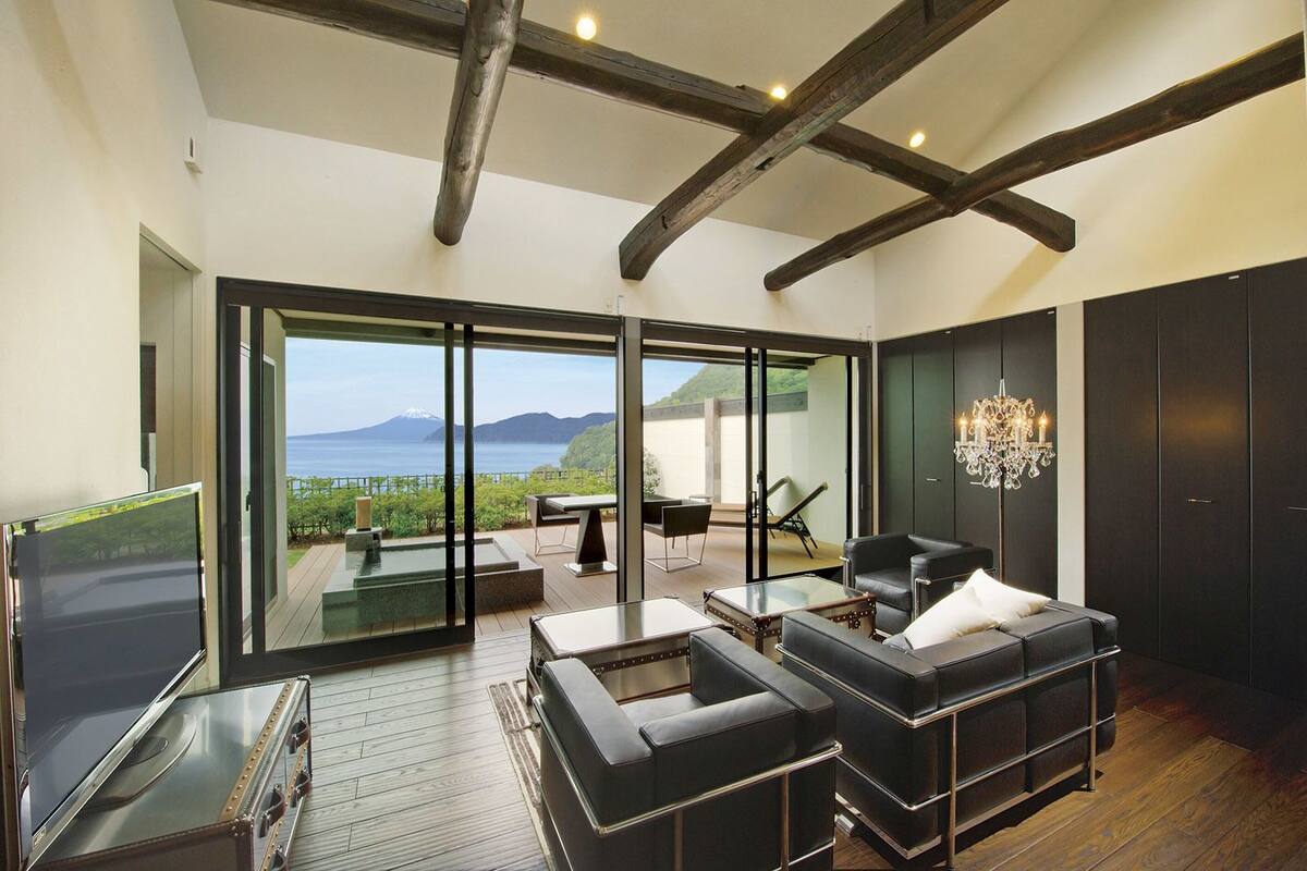 Un interior moderno con una pared de vidrio que ofrece vistas a un paisaje montañoso.