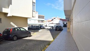Una calle estrecha con coches aparcados y edificios a ambos lados.