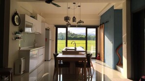 Eine moderne Küche mit Essbereich, großen Fenstern und einem Deckenventilator.