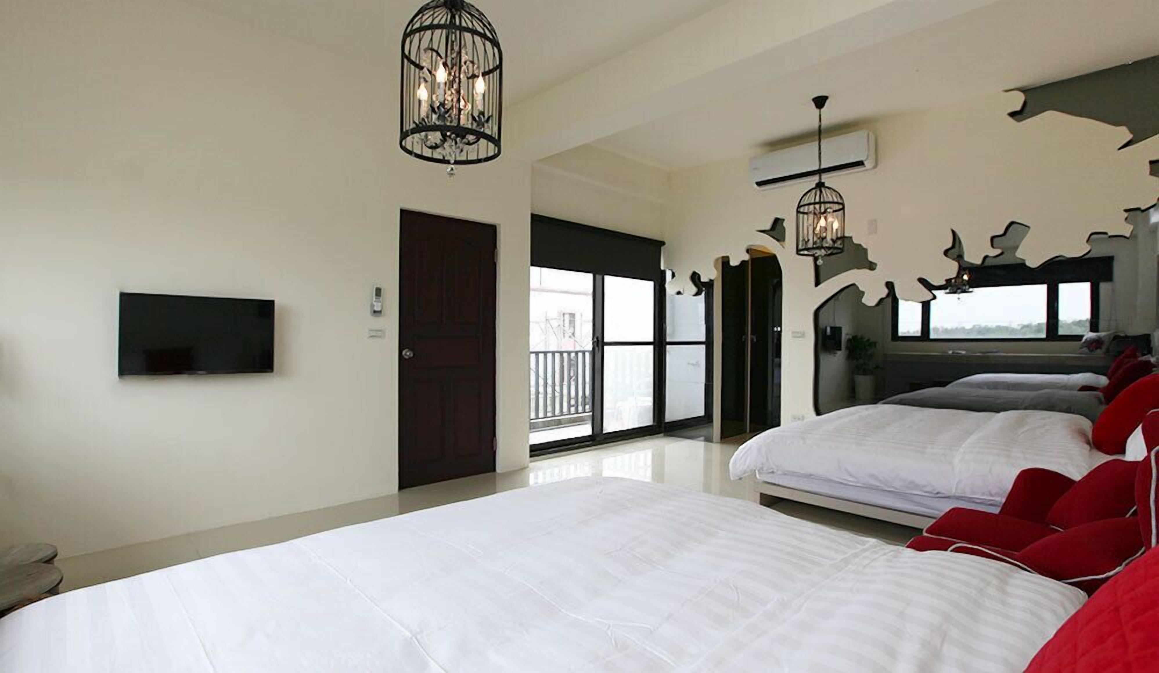 Una habitación de hotel moderna con una cama grande, televisión y un balcón con vistas.