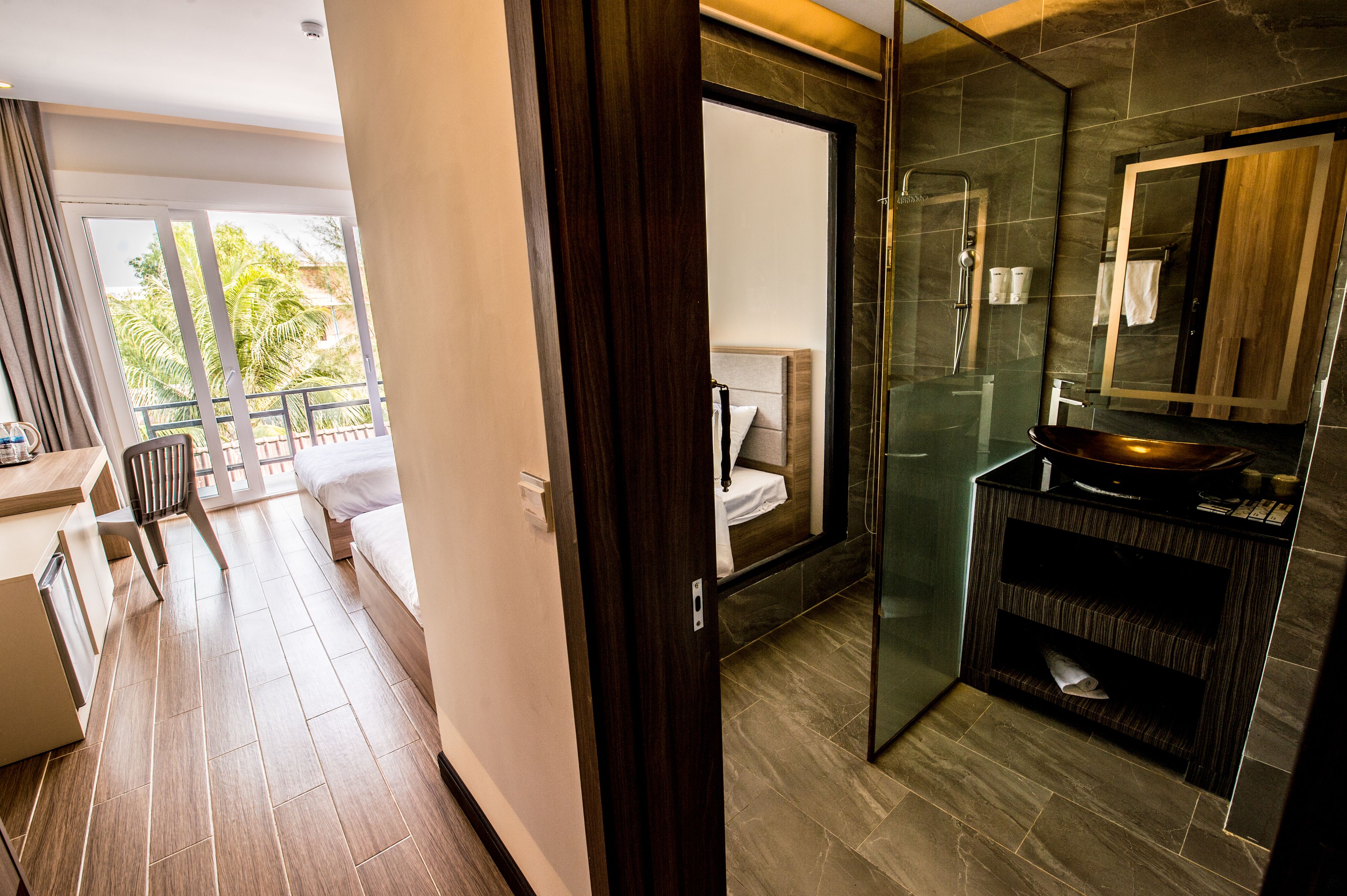 A modern bathroom with a glass shower, a dark wood vanity, and a large mirror.