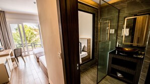 A modern bathroom with a glass shower, a dark wood vanity, and a large mirror. - Hai Ma Hotel (Sihanoukville)