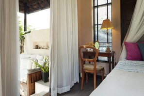 Relax in this serene bedroom with a large bed, nightstand, and comfortable chair.