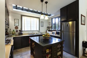 Enjoy cooking in this well-equipped kitchen with a central island, oven, and stainless steel appliances.