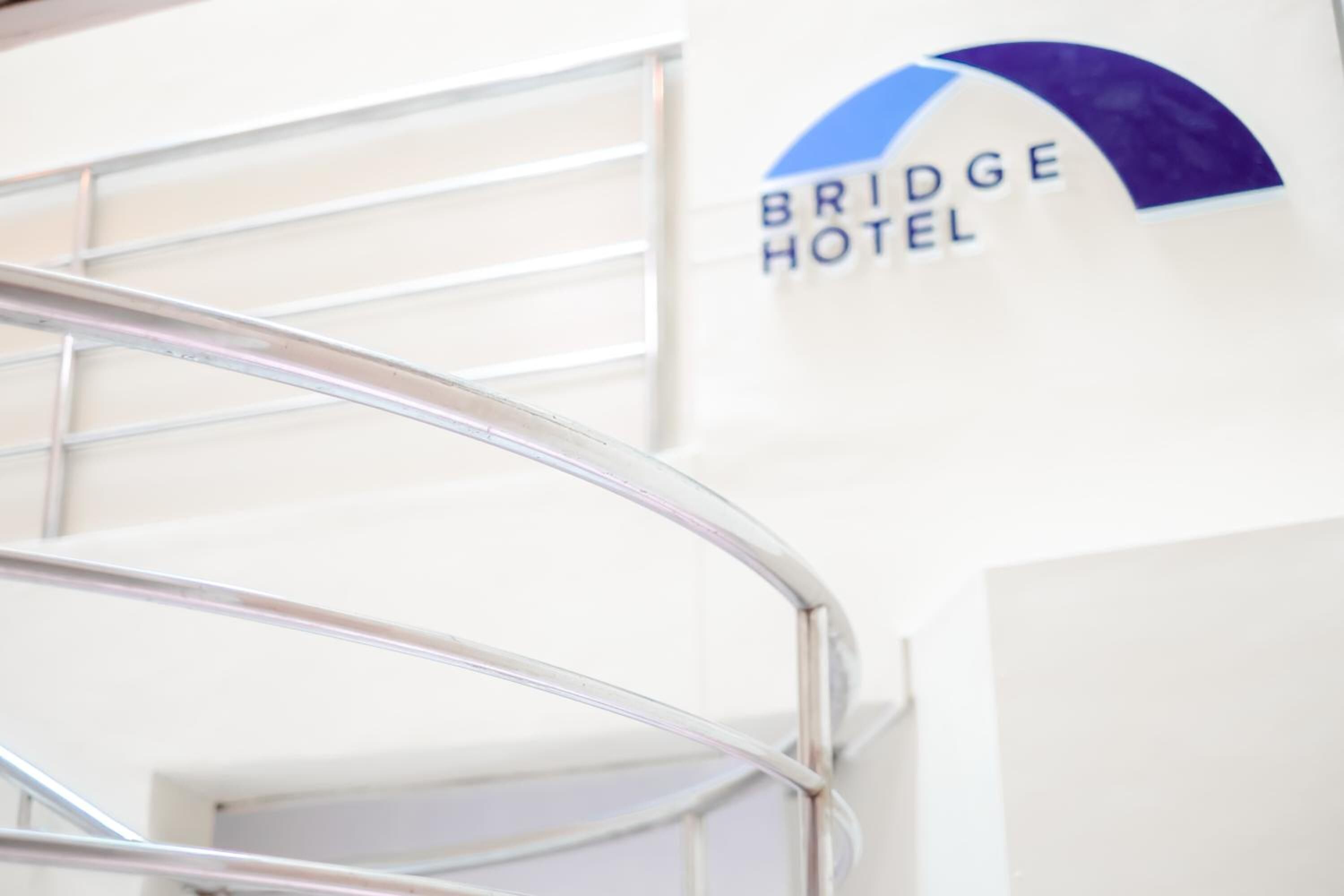 A metal staircase with a sign for Bridge Hotel in the background.