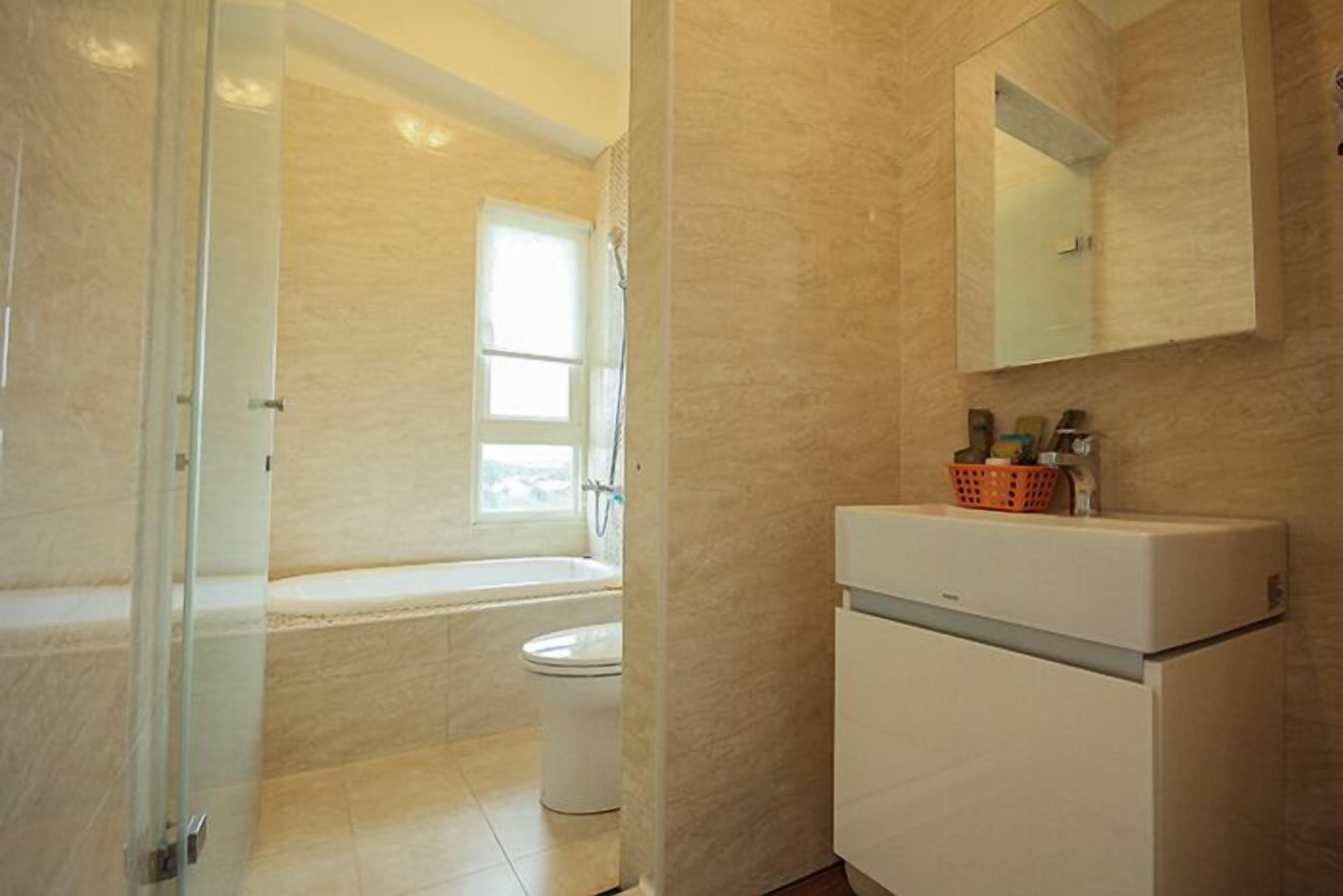 Un bagno con vasca, WC e un mobile bianco con specchio sopra.
