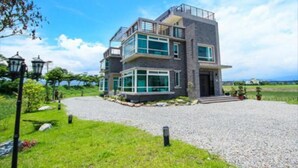 Een modern herenhuis met grindpad, grote ramen en een balkon.