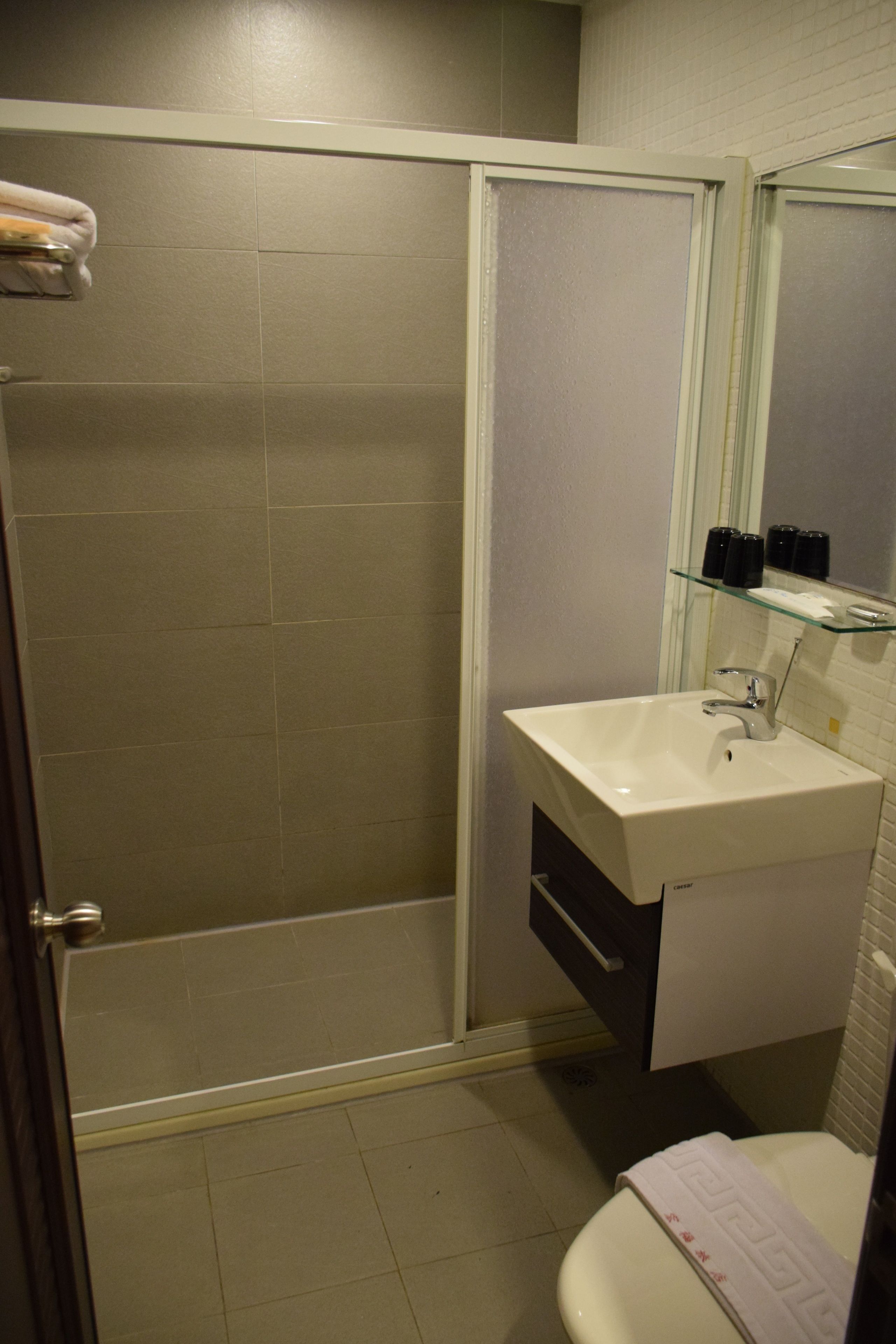 Un baño con ducha, lavamanos e inodoro.