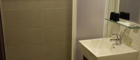 Un baño con ducha, lavamanos e inodoro.