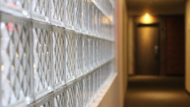 A corridor with a patterned wall and a door at the end. - Home Full Hotel (Jincheng)
