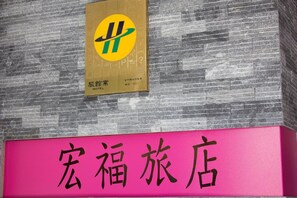 A hotel sign with a yellow and green logo and Chinese characters. - Home Full Hotel (Jincheng)