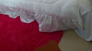 A bed with a quilted white duvet, a wooden headboard, and red pillows. - Sunset Paradise Baringo 11 (Shanzu)