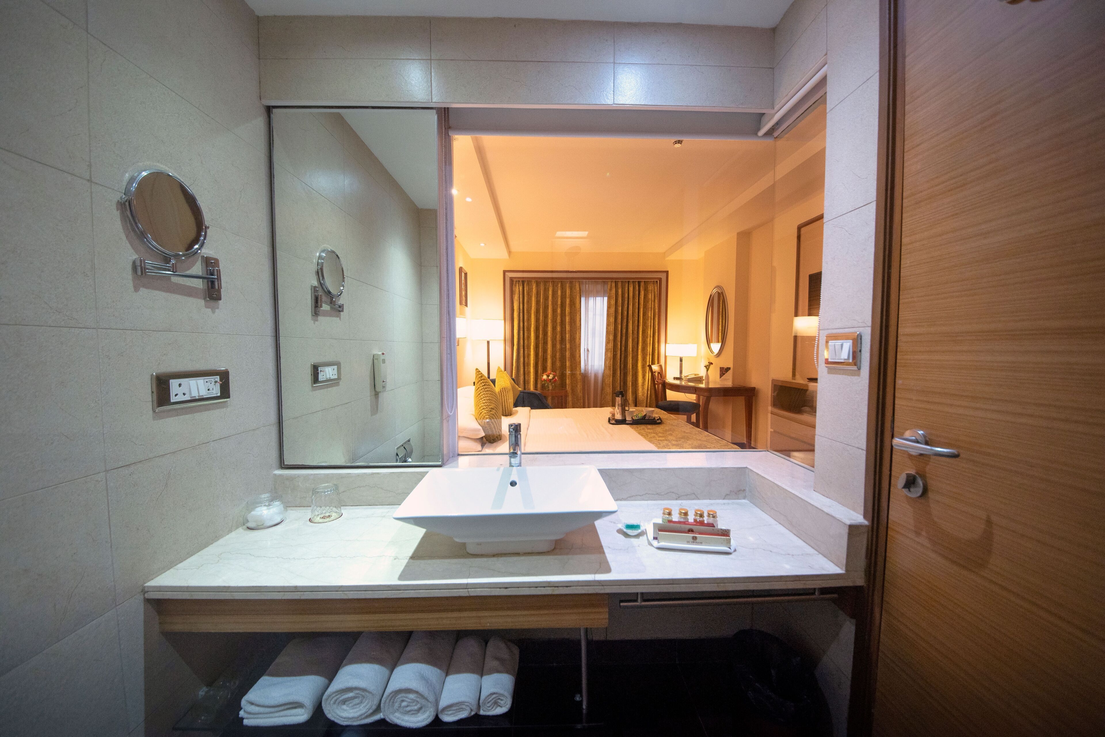 A modern bathroom with a large mirror, a sink, and a towel rack.