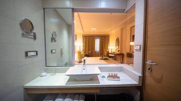 A modern bathroom with a large mirror, a sink, and a towel rack.