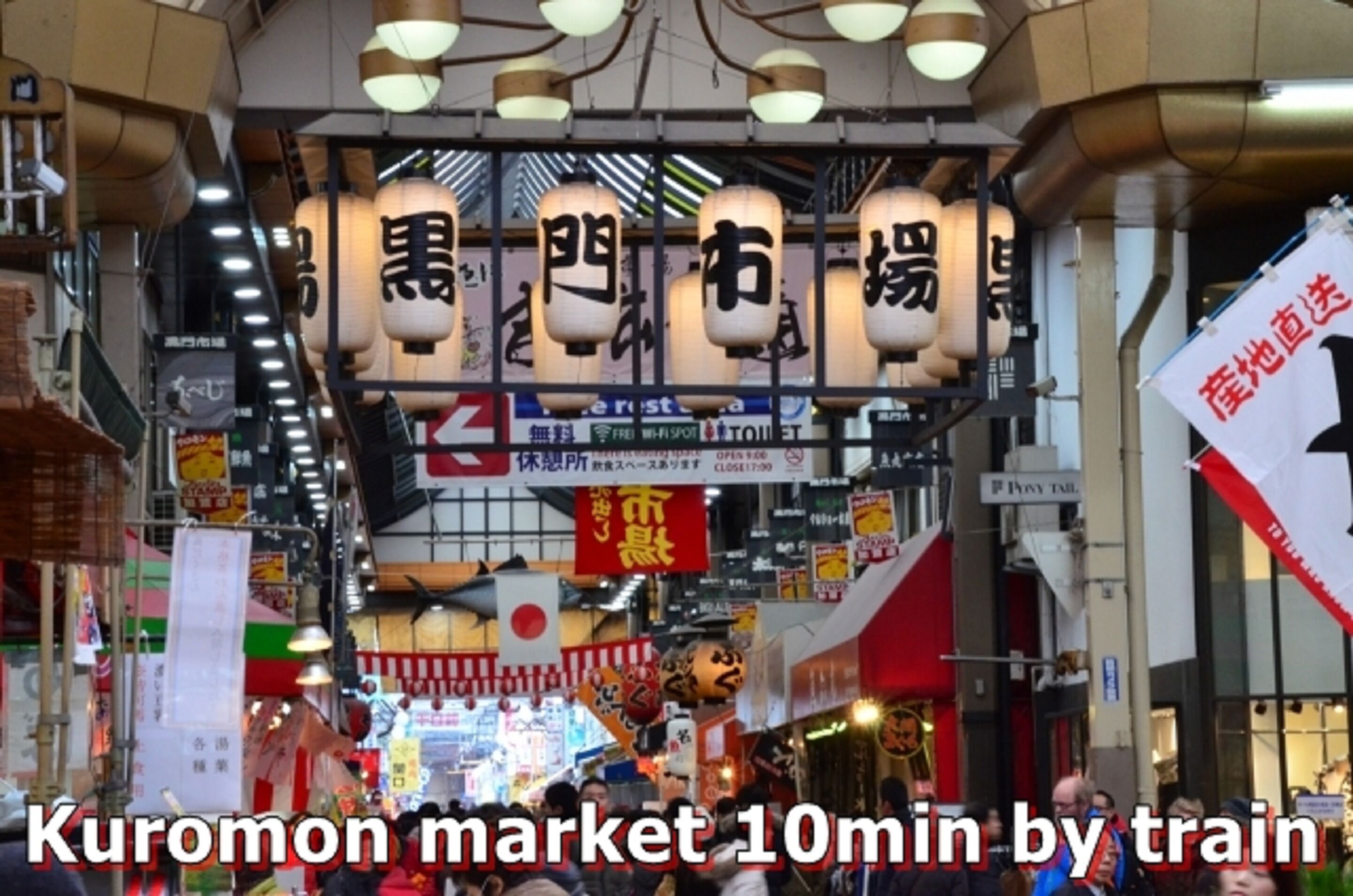 A busy market scene with traditional Japanese lanterns and signs in Japanese.