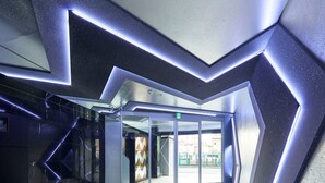 A modern lobby with geometric wall designs and a glass entrance.