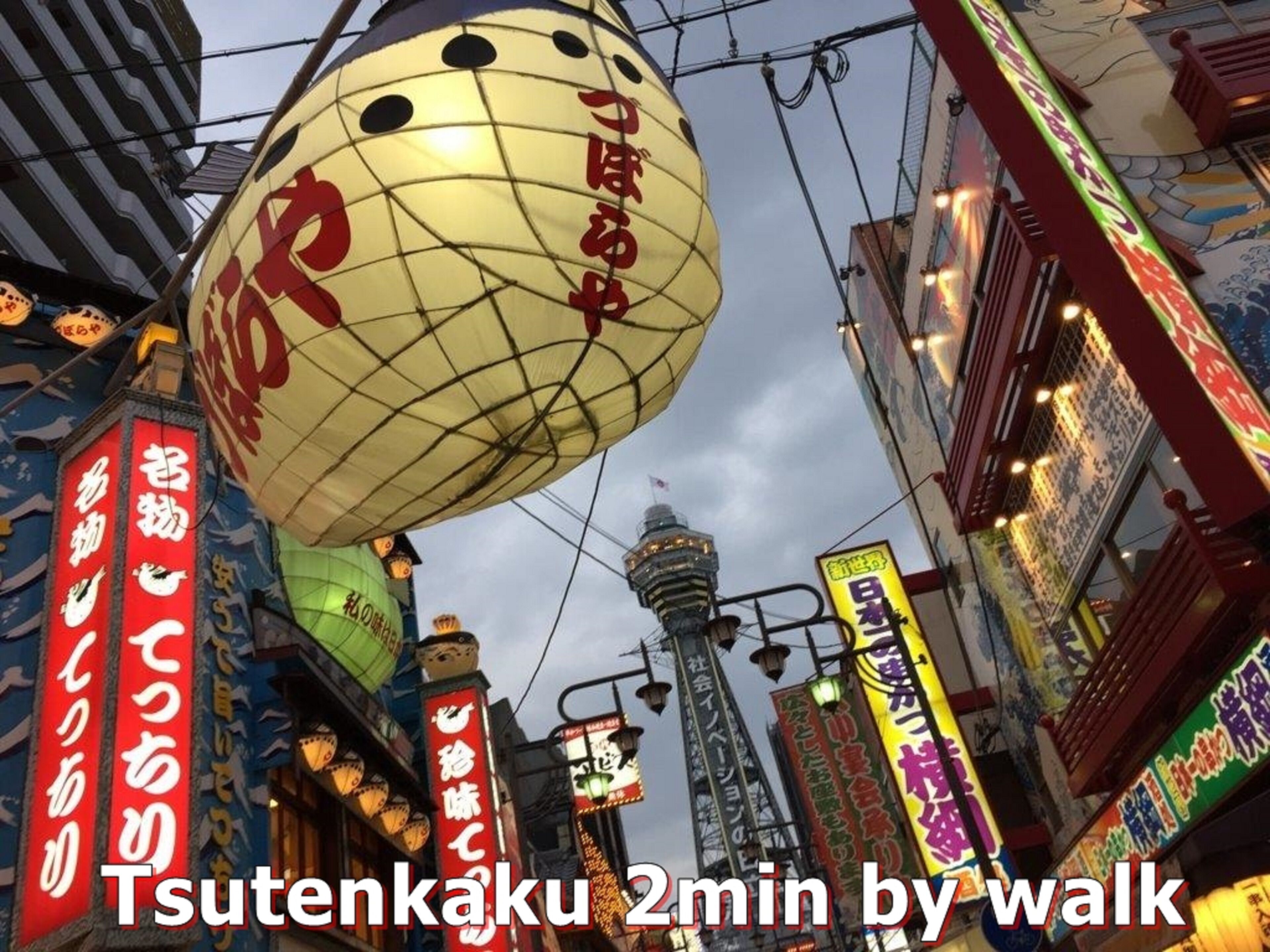 A street scene with traditional Japanese lanterns and neon signs.