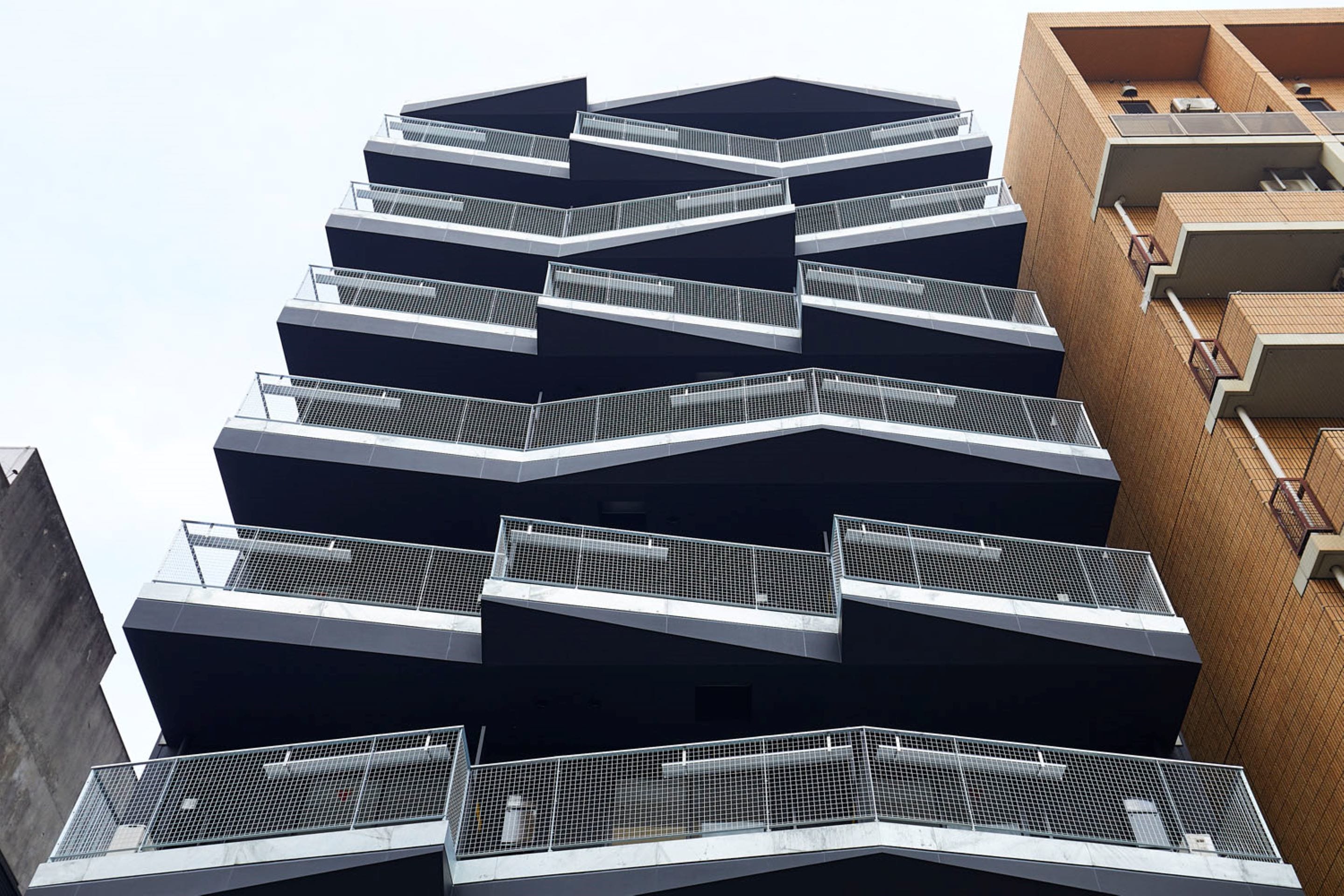 A multi-story building with a modern architectural design, featuring a series of balconies and a prominent central atrium.