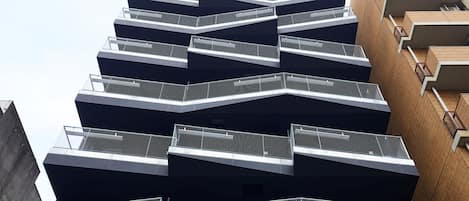A multi-story building with a modern architectural design, featuring a series of balconies and a prominent central atrium.