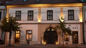 A building with a large arched entrance, multiple windows, and a sign that reads "IDEA". - Guest House 1568 (Cluj-Napoca)