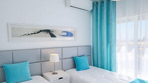 A hotel room with two beds, a nightstand with a lamp, a wall-mounted air conditioner, and a window with curtains. - T2-2º vista mar, piscina, bbq, para a praia vai a (Albufeira)
